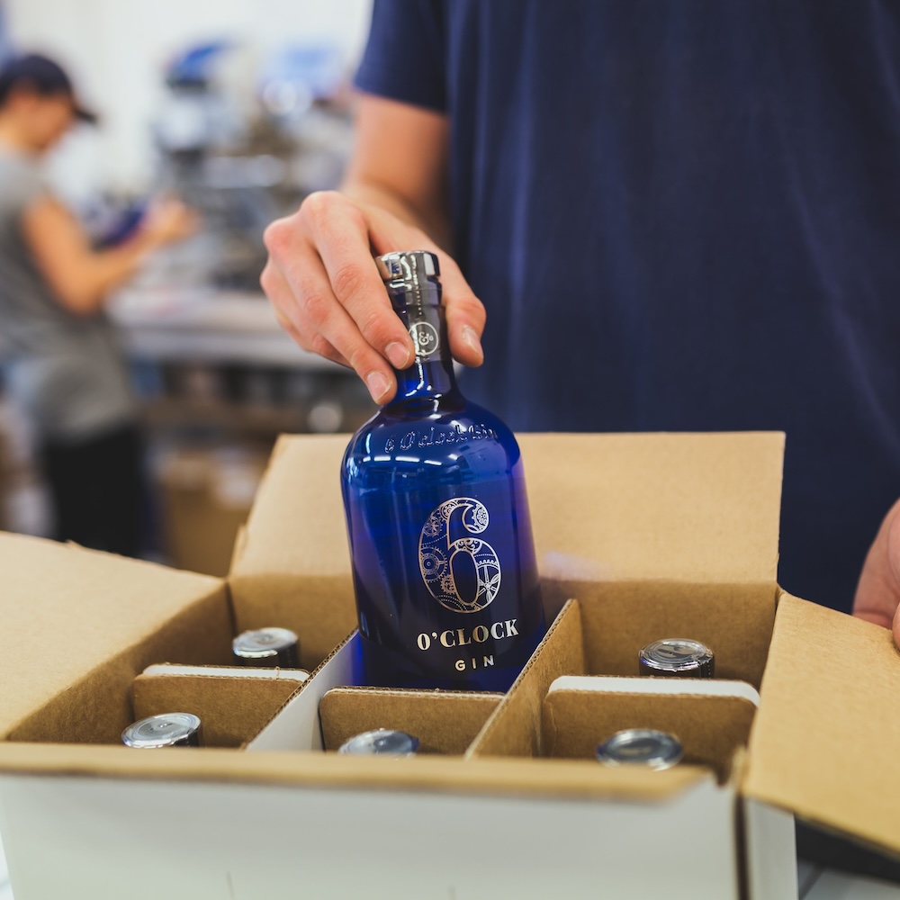 A 6 o'clock gin bottle being packed into a box